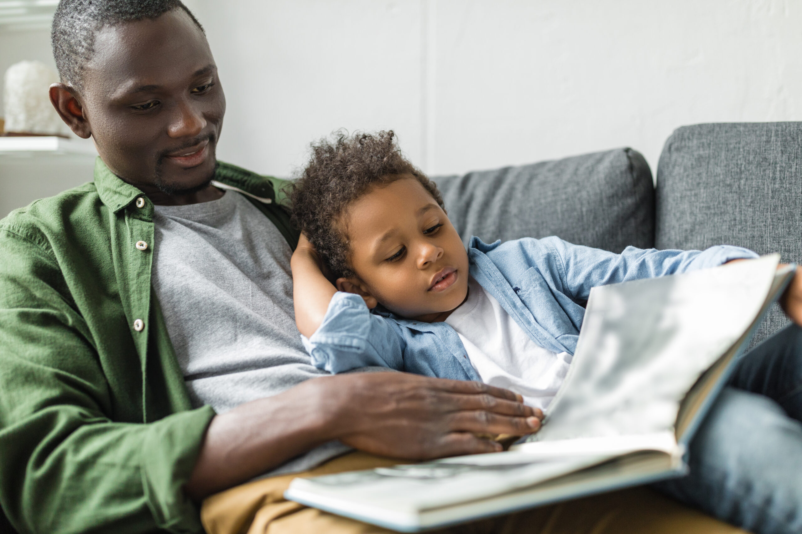 Dad reading book to son cuddled