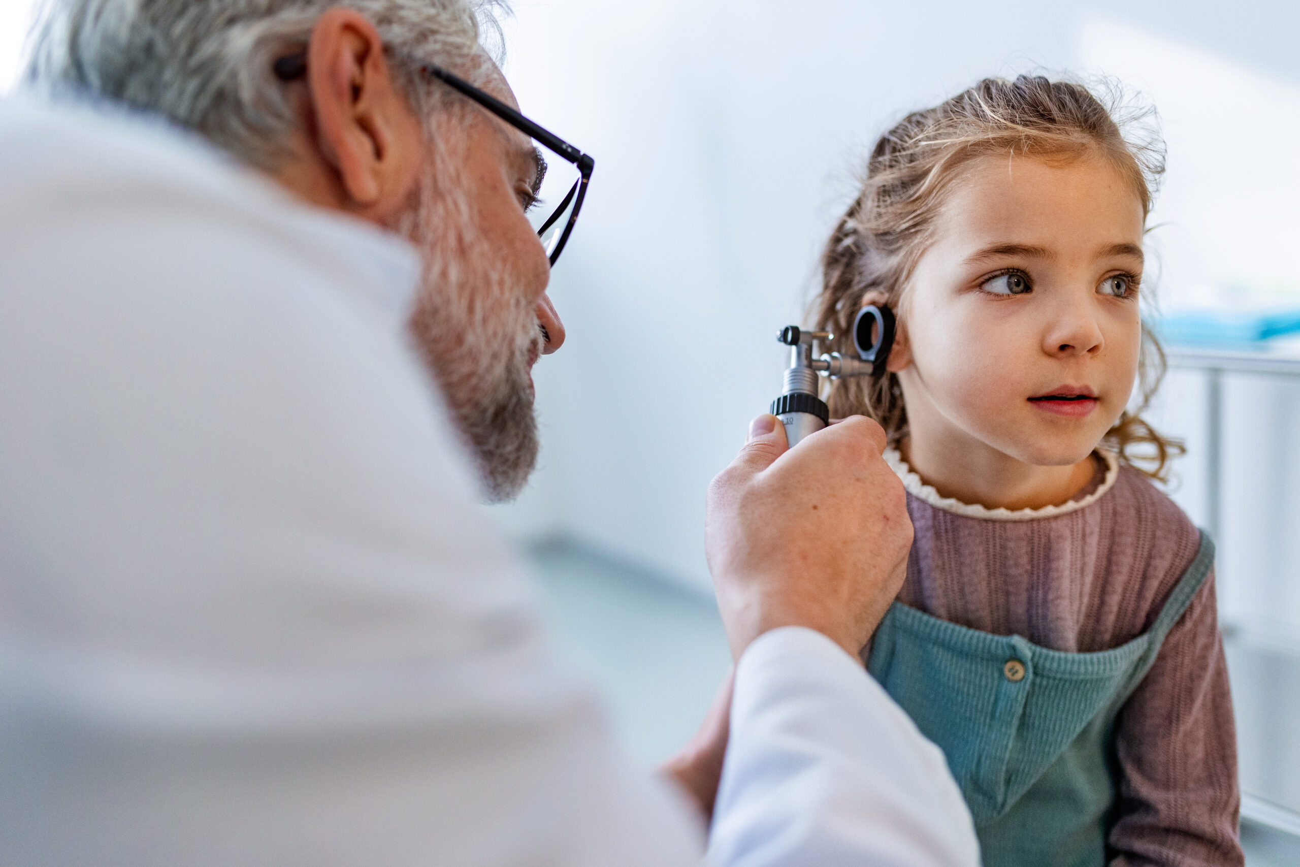 Doctor examining little girl's ear