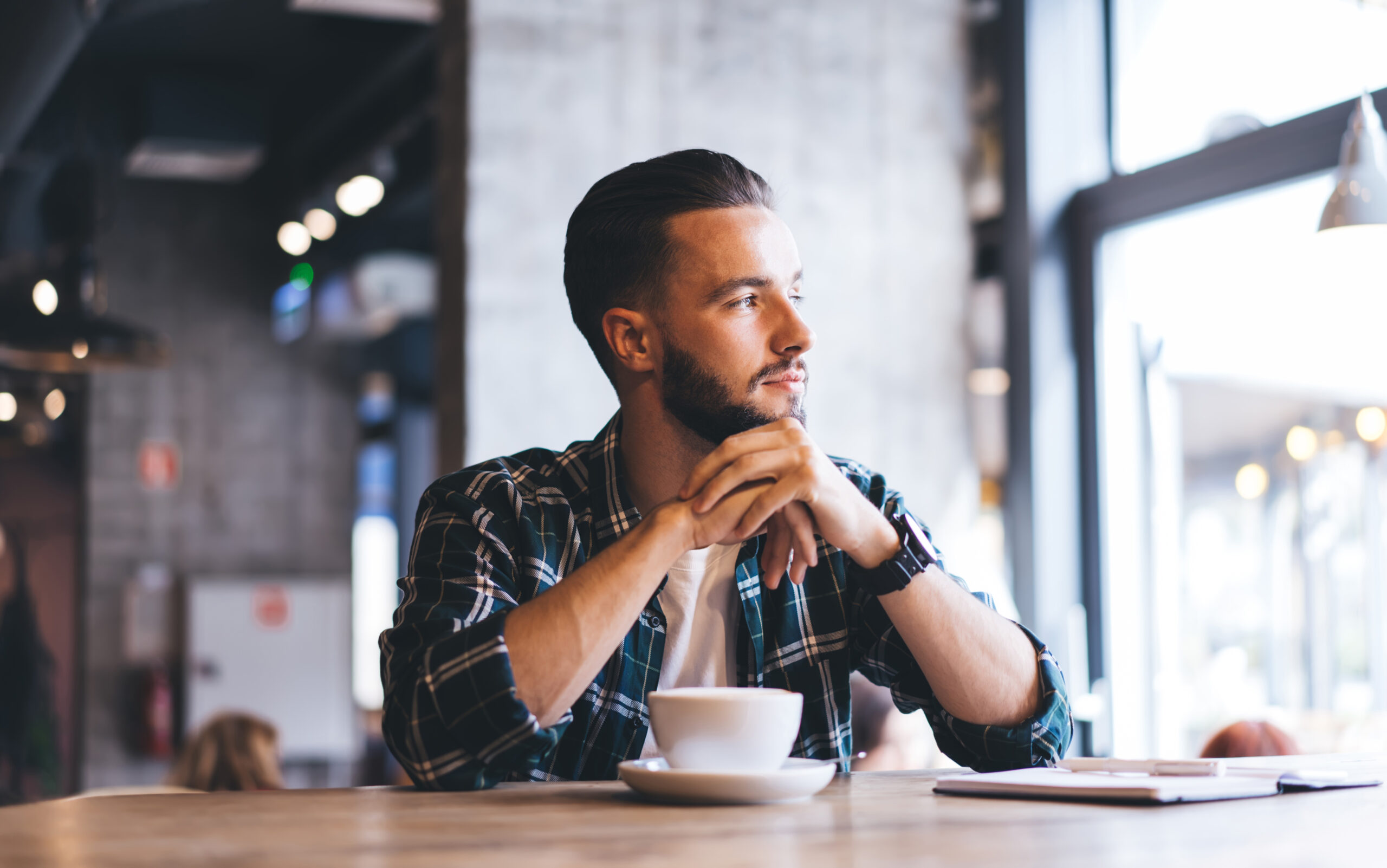 Man drinking coffee looking into distance