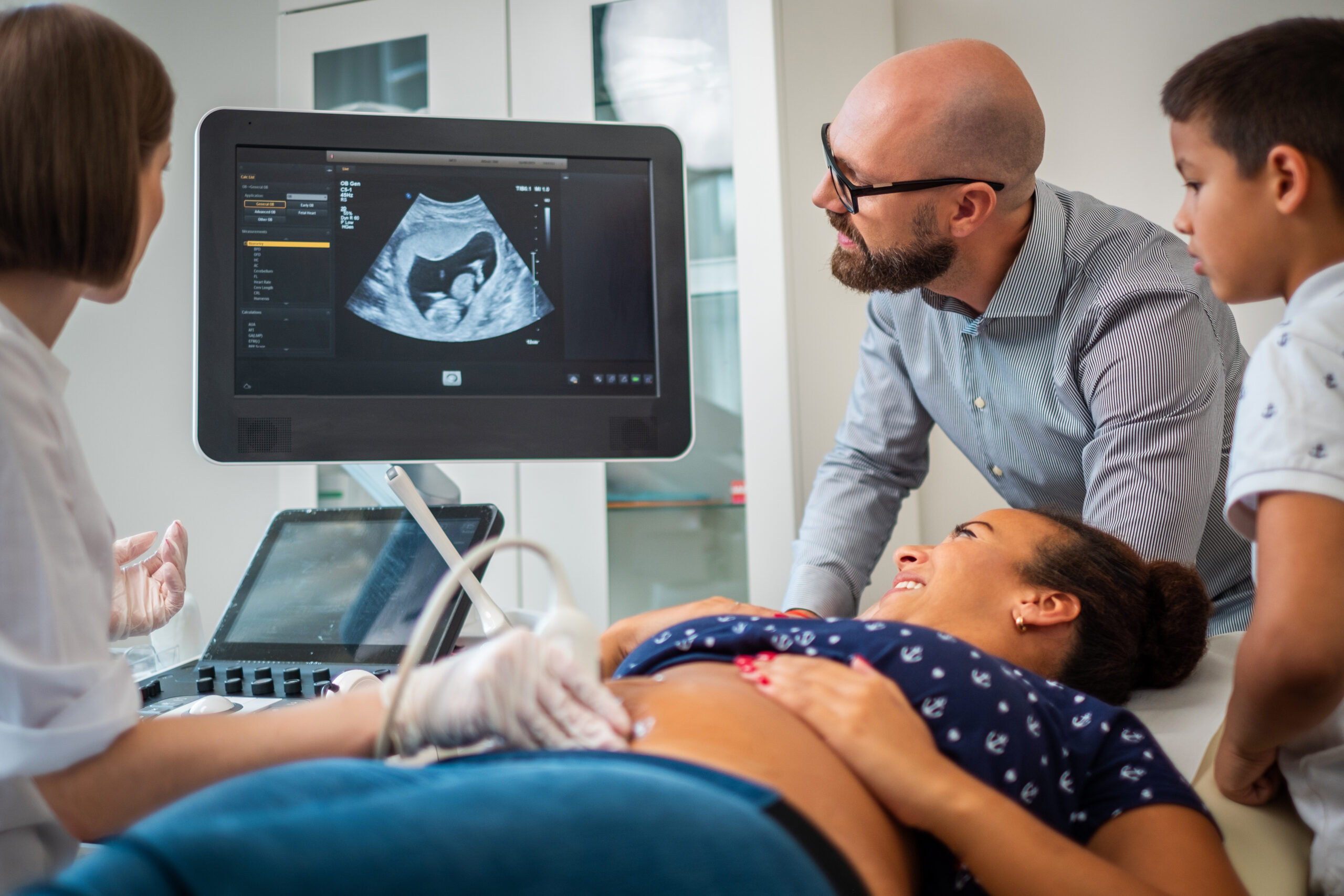 Pregnant woman and her family on utltrasonographic examination at hospital