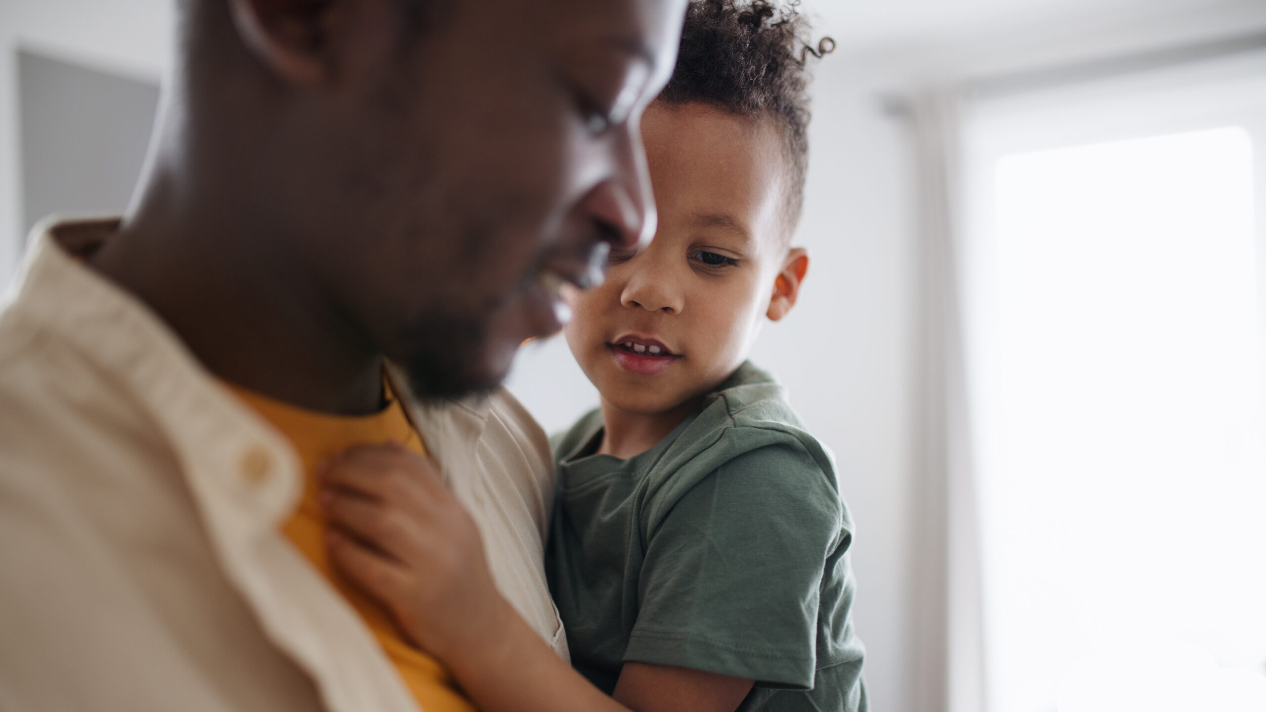 Father holding small son at home