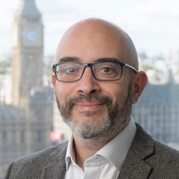 Bald man wearing glasses smiling for professional headshot