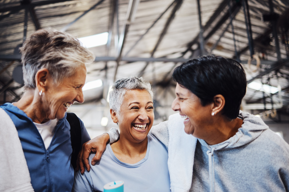 Group of friends in gym center for workout and cardio, laughing together.