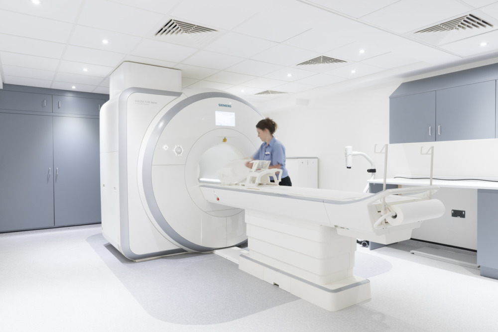 Magnetic resonance imaging (MRI) scanner in a clinical imaging room with a patient table positioned inside the scanner.