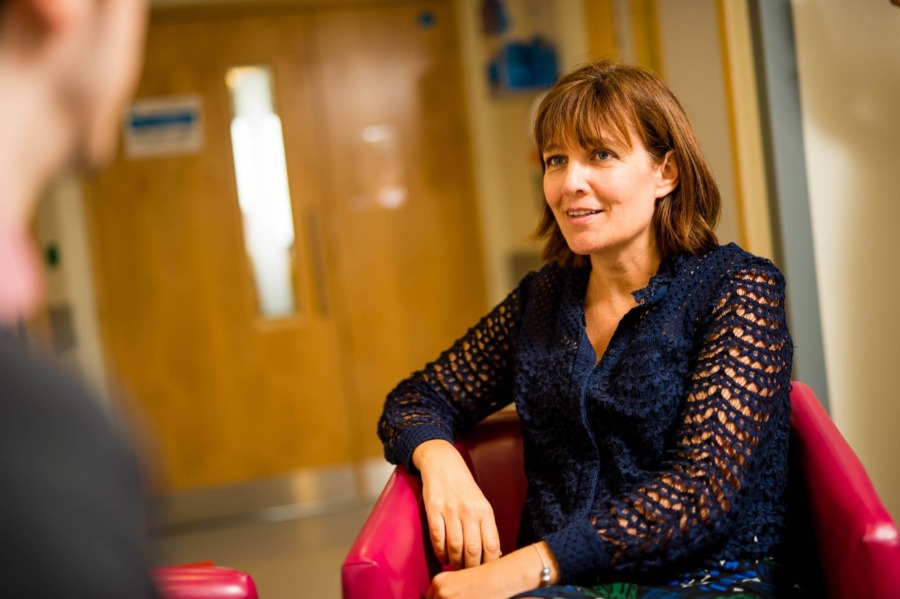 Patient seated in a clinic consultation room speaking with a healthcare professional during a fertility appointment