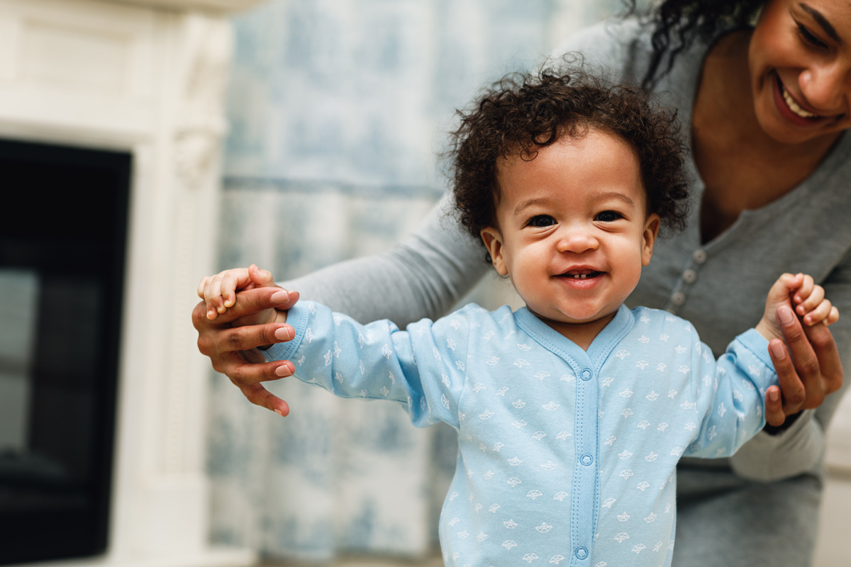 Happy child being walking with mothers help