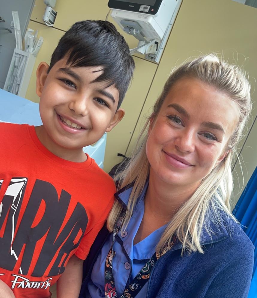 Smiling brunette boy with smiling blonde nurse