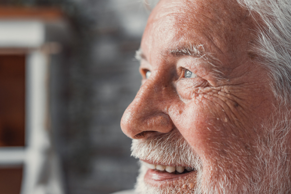 Close-up side profile of an older man smiling.