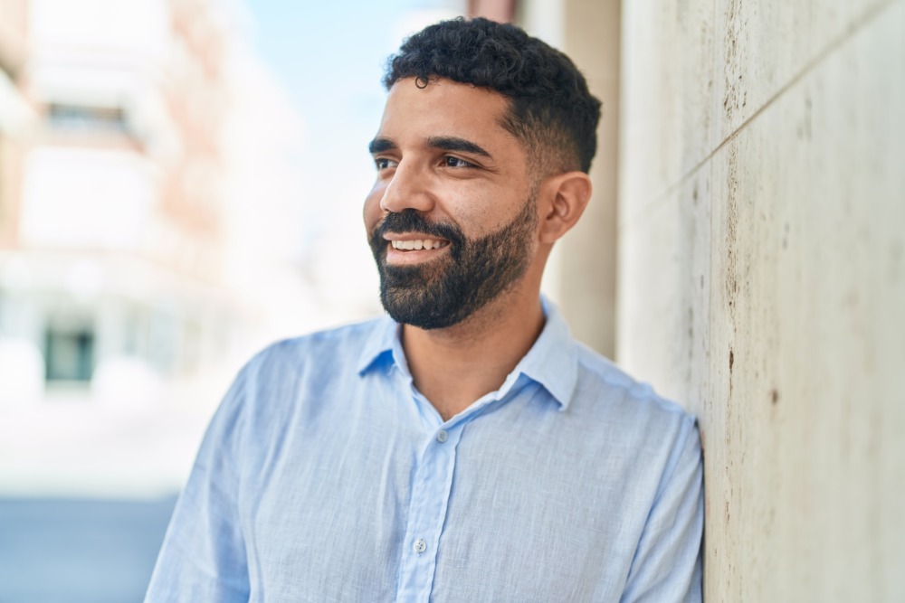 Young arab man smiling confident looking to the side at street